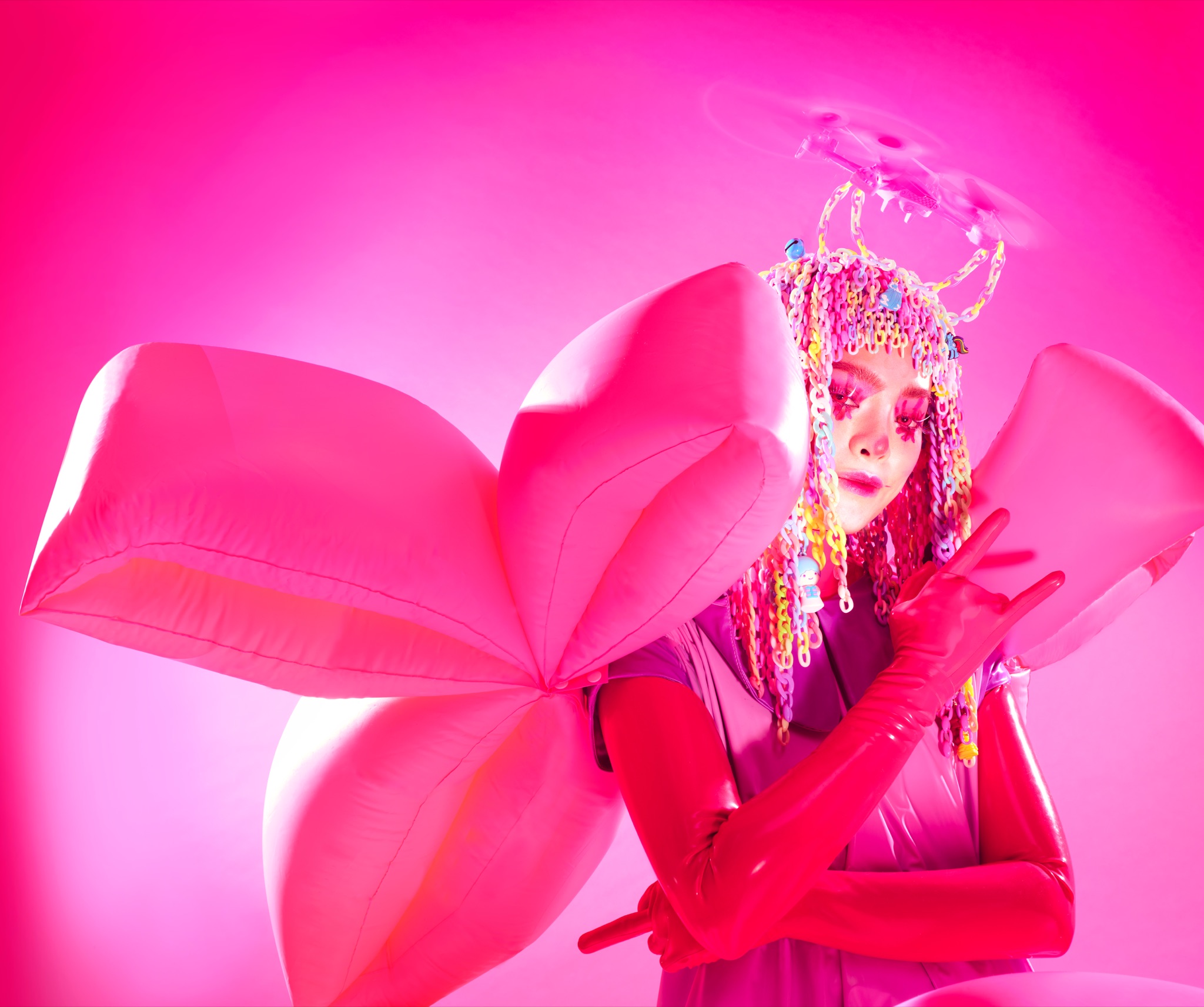 Pyra in a vivid pink sculptural costume for her essay on ten years as an Asian artist